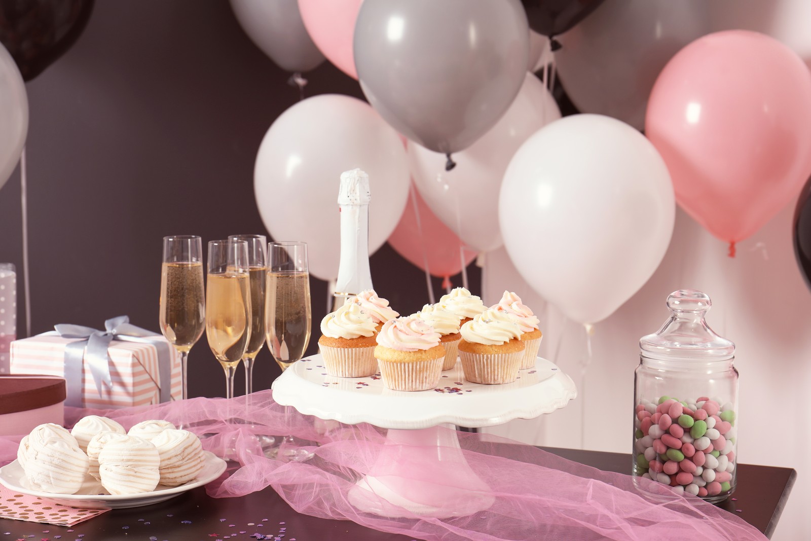 Photo of party treats on table in room decorated with balloons