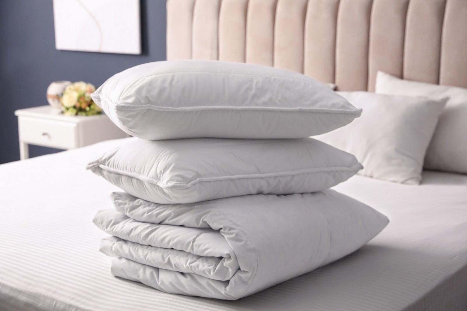 Photo of soft folded blanket and pillows on bed indoors