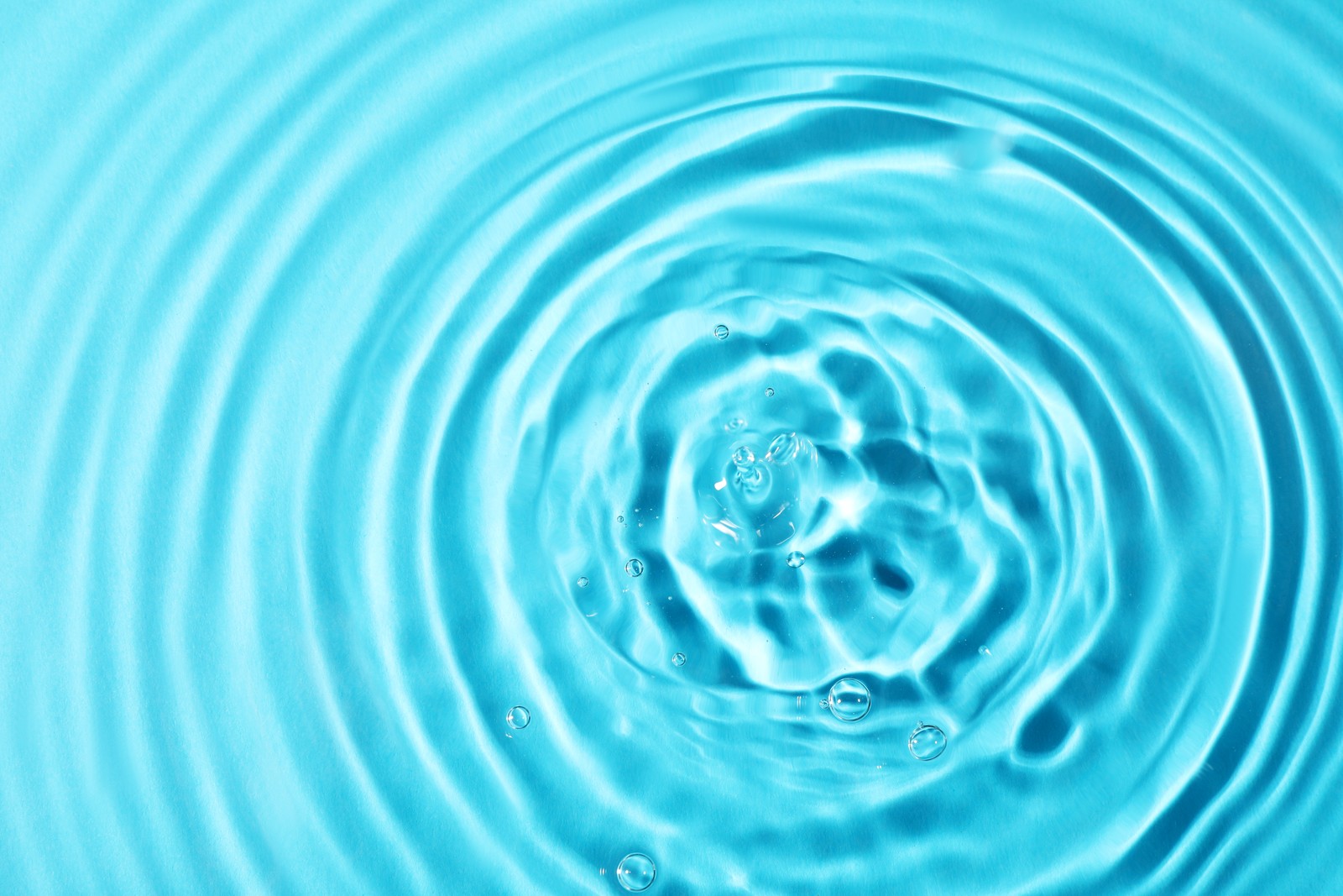 Photo of closeup view of water with rippled surface on light blue background