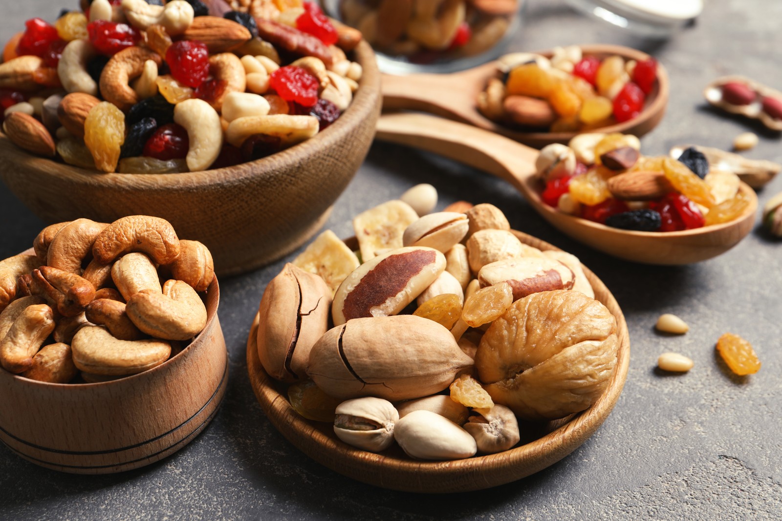 Photo of composition of different dried fruits and nuts on color background, closeup
