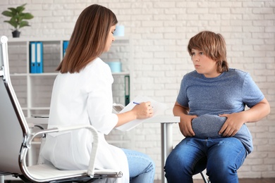 Overweight boy consulting with doctor in clinic