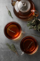Photo of Aromatic herbal tea with thyme on grey table, flat lay