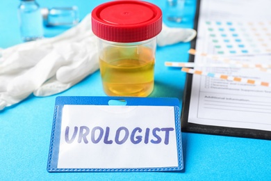 Urine sample and card with word UROLOGIST on table