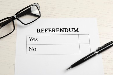 Referendum ballot with pen and glasses on white wooden table, flat lay
