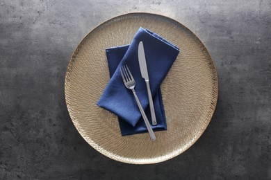 Photo of Tray with blue napkins and cutlery on grey table, top view