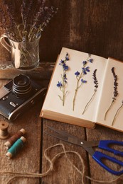 Photo of Composition with beautiful dried flowers and vintage camera on wooden table
