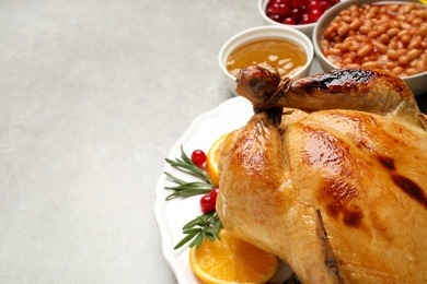 Traditional Thanksgiving day feast with delicious cooked turkey and other seasonal dishes served on grey table, closeup. Space for text