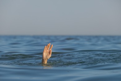 Photo of Drowning woman reaching for help in sea