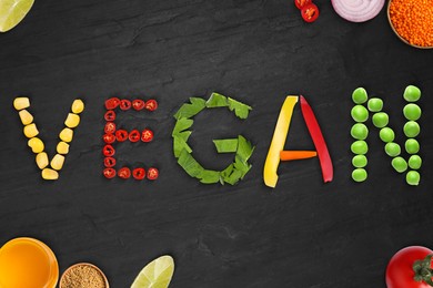 Word VEGAN made of different fresh tasty vegetables on black background, flat lay