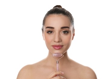 Woman using natural pink quartz face roller on white background