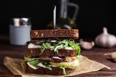 Delicious fresh eggplant sandwich served on wooden table, closeup
