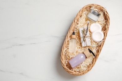 Spa gift set with different personal care products on white marble table, top view. Space for text