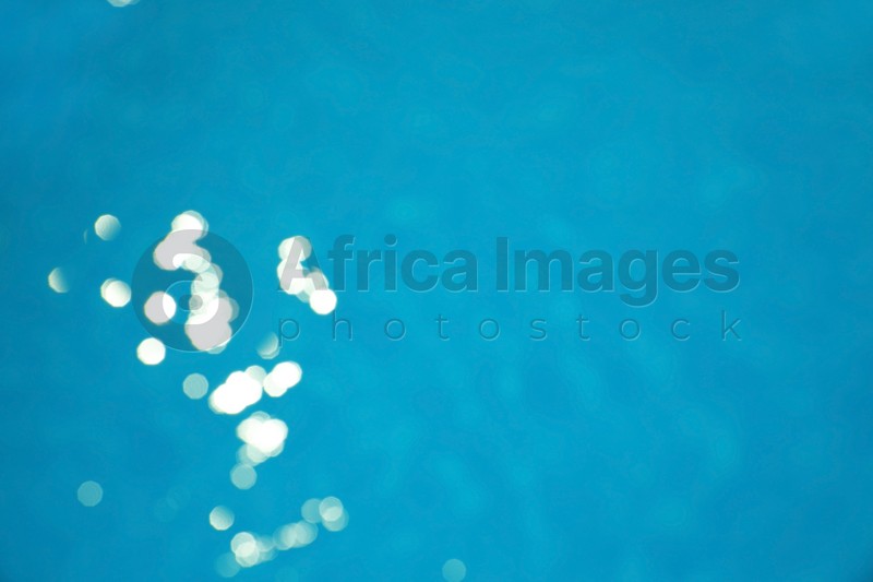 Surface of swimming pool with clean blue water as background. Bokeh effect