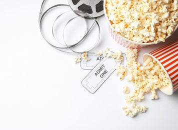 Popcorn, tickets and movie reel on white background, top view. Cinema snack