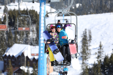 Couple taking selfie while lifting at mountain ski resort. Winter vacation