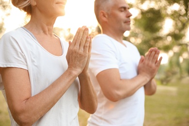 Couple practicing yoga in park at morning, closeup