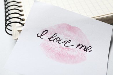 Phrase I Love Me and lipstick kiss mark on paper, closeup