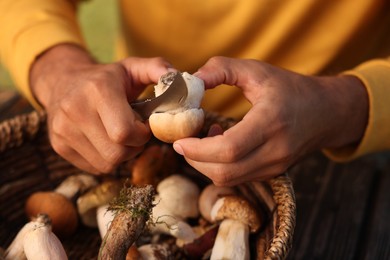 Man cutting fresh mushroom at table, closeup