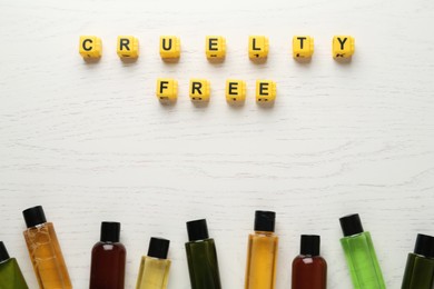 Cubes with text Cruelty Free and cosmetic products on white wooden table, flat lay. Stop animal tests