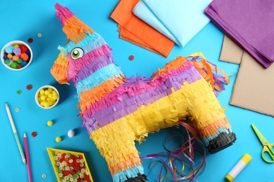Flat lay composition with cardboard donkey and materials on blue background. Pinata diy