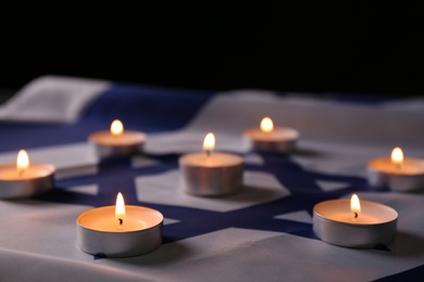 Burning candles on flag of Israel. Holocaust memory day