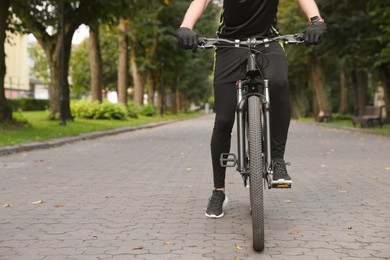 Man riding bicycle on road outdoors, closeup. Space for text