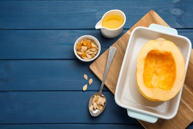 Photo of Raw spaghetti squash half in baking dish with seeds and oil on blue wooden table, flat lay. Space for text