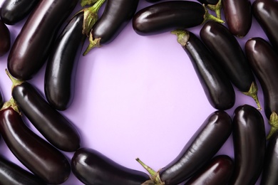 Frame of raw ripe eggplants on light background, flat lay. Space for text