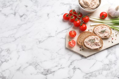 Photo of Sandwiches with delicious lard spread and vegetables on white marble table, flat lay. Space for text