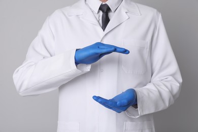 Dentist holding something on light grey background, closeup