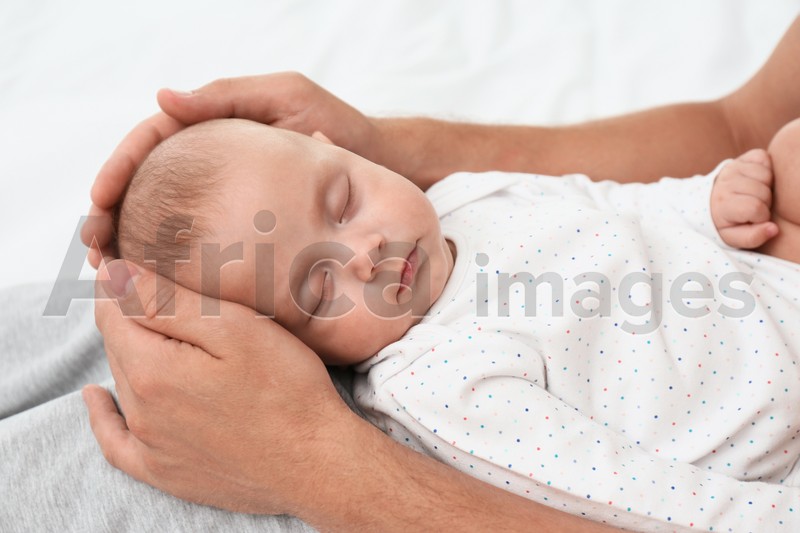 Father holding his cute sleeping baby, closeup