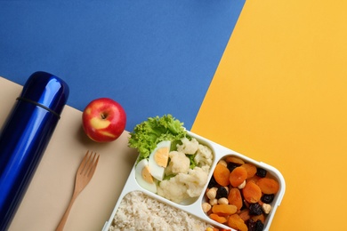 Thermos and lunch box with food on color background, flat lay. Space for text