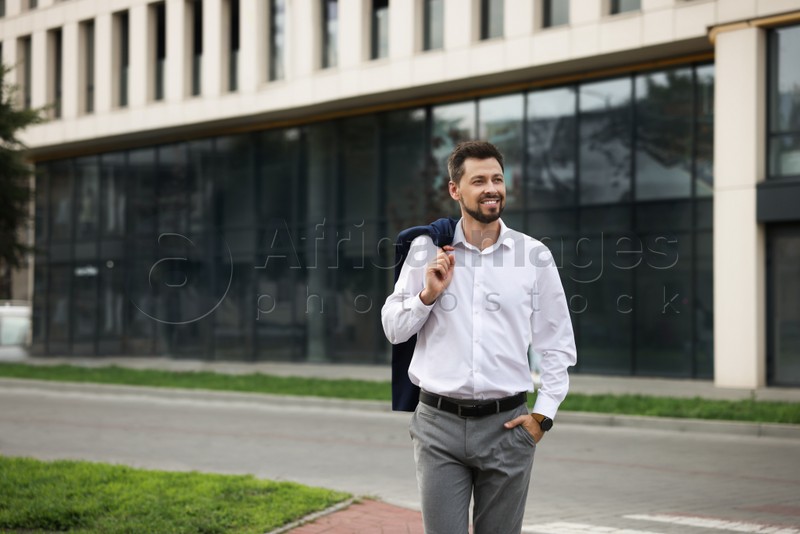 Handsome bearded businessman walking on city street