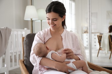 Young woman breastfeeding her little baby at home