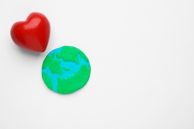 Model of planet and red heart on white background, top view with space for text. Earth Day