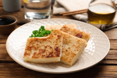 Photo of Delicious turnip cake with parsley served on wooden table