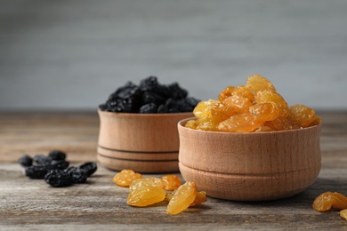Bowls with raisins on wooden table. Dried fruit as healthy snack