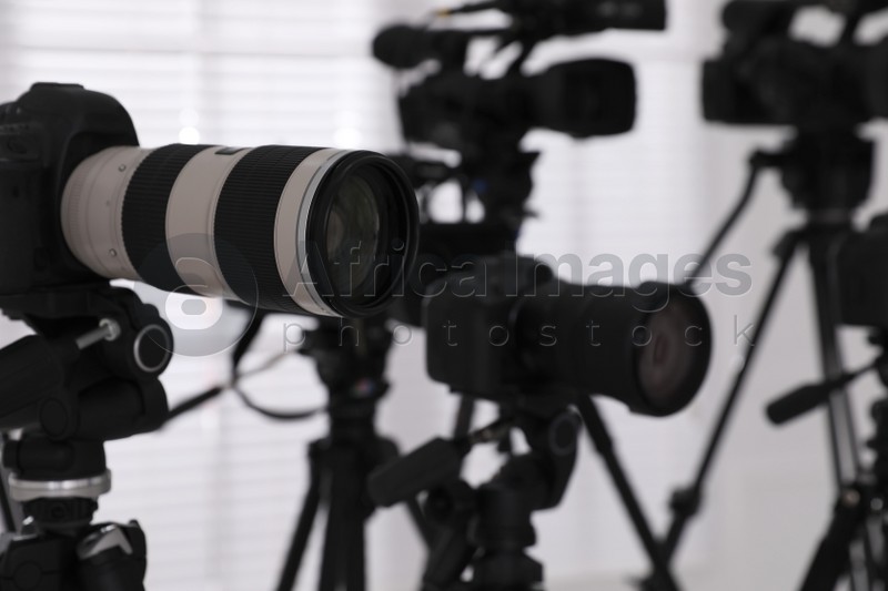 Photo of Modern video cameras indoors, closeup. Professional media equipment for broadcasting event