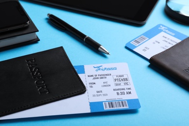 Passports with avia tickets on light blue background, closeup. Travel agency concept