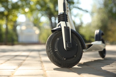 Modern electric kick scooter outdoors on sunny day, closeup. Space for text