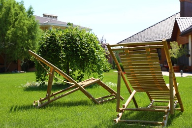 Photo of Wooden deck chairs in beautiful garden on sunny day