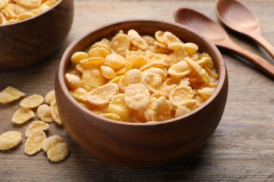 Tasty cornflakes with milk served on wooden table, closeup