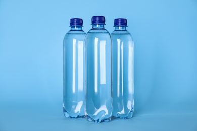 Plastic bottles with water on light blue background