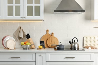 Countertop with stove, products and cooking utensils in kitchen