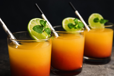 Fresh alcoholic Tequila Sunrise cocktails on grey table, closeup