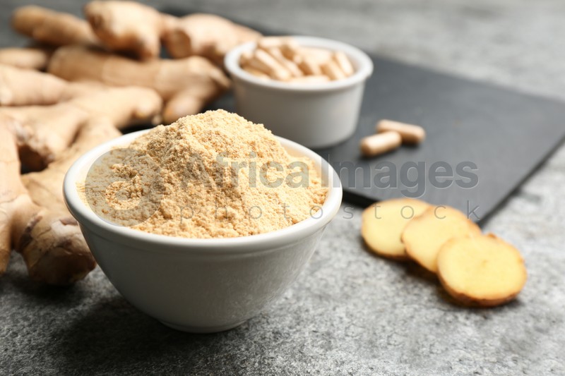 Photo of Dry, fresh and capsuled ginger on grey table. Space for text