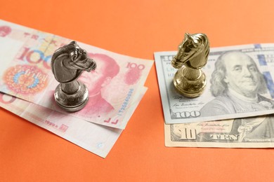 Photo of Chess pieces and money on orange background. China–United States trade war
