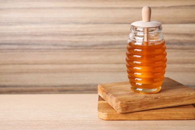 Tasty organic honey on wooden table, space for text