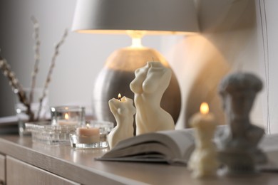 Beautiful body shaped candles on table indoors