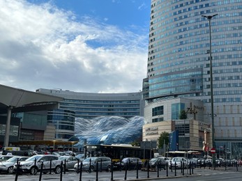 Photo of WARSAW, POLAND - JULY 17, 2022: View of shopping mall and parked cars outdoors